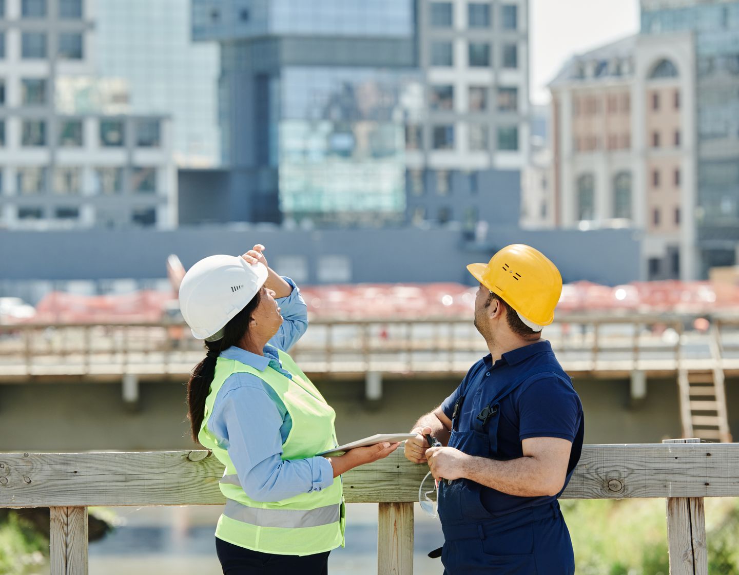 Engineers in hard hats reviewing plans together at a construction site