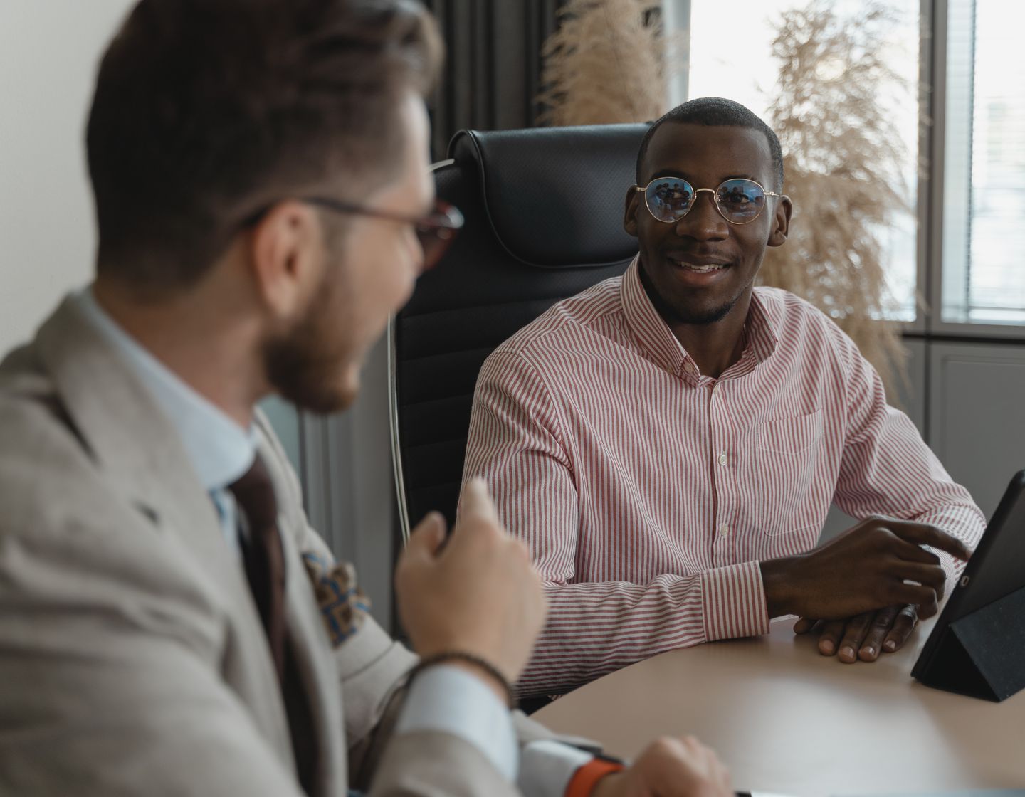 Two professionals having a conversation across a desk during an interview
