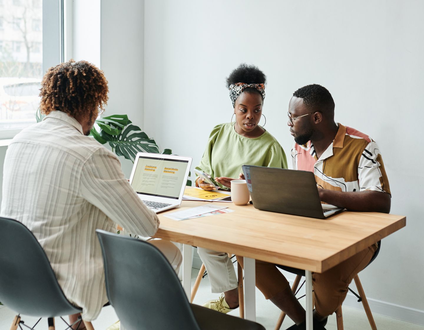 A team discussing plans and reviewing work together around a laptop
